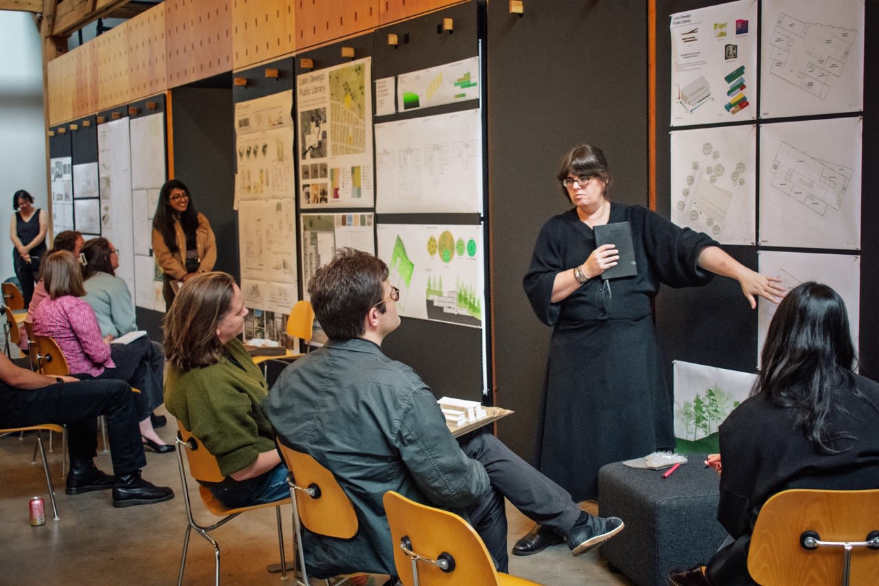 Students present at midterm reviews at the Bora office.