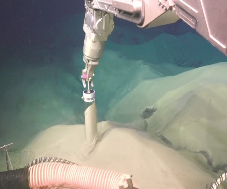 robotic arm collecting ash in a plastic tube