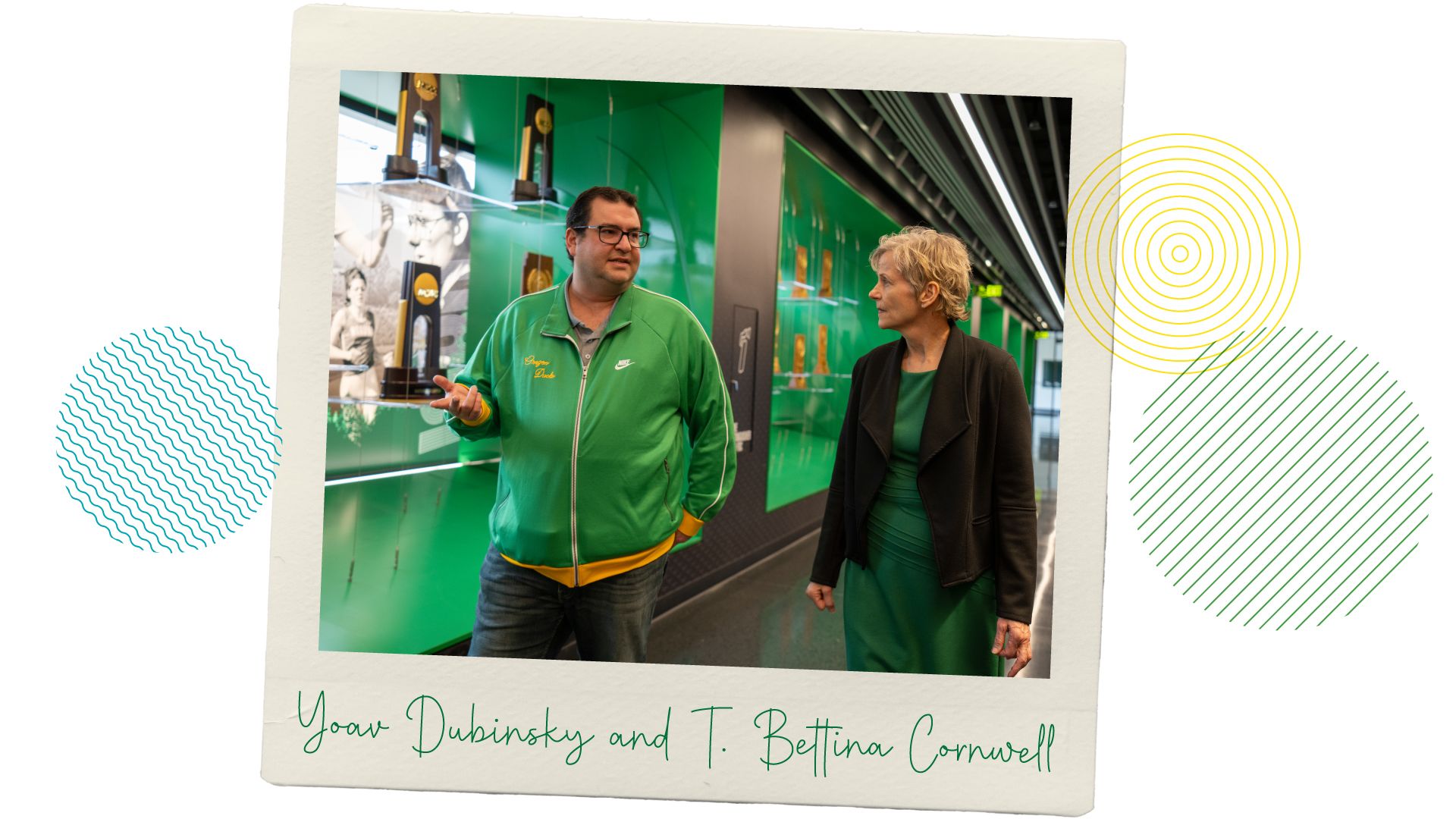 Professors Yoav Dubinsky and T. Bettina Cornwell walking and chatting through the halls of the Hayward Field tower lobby.