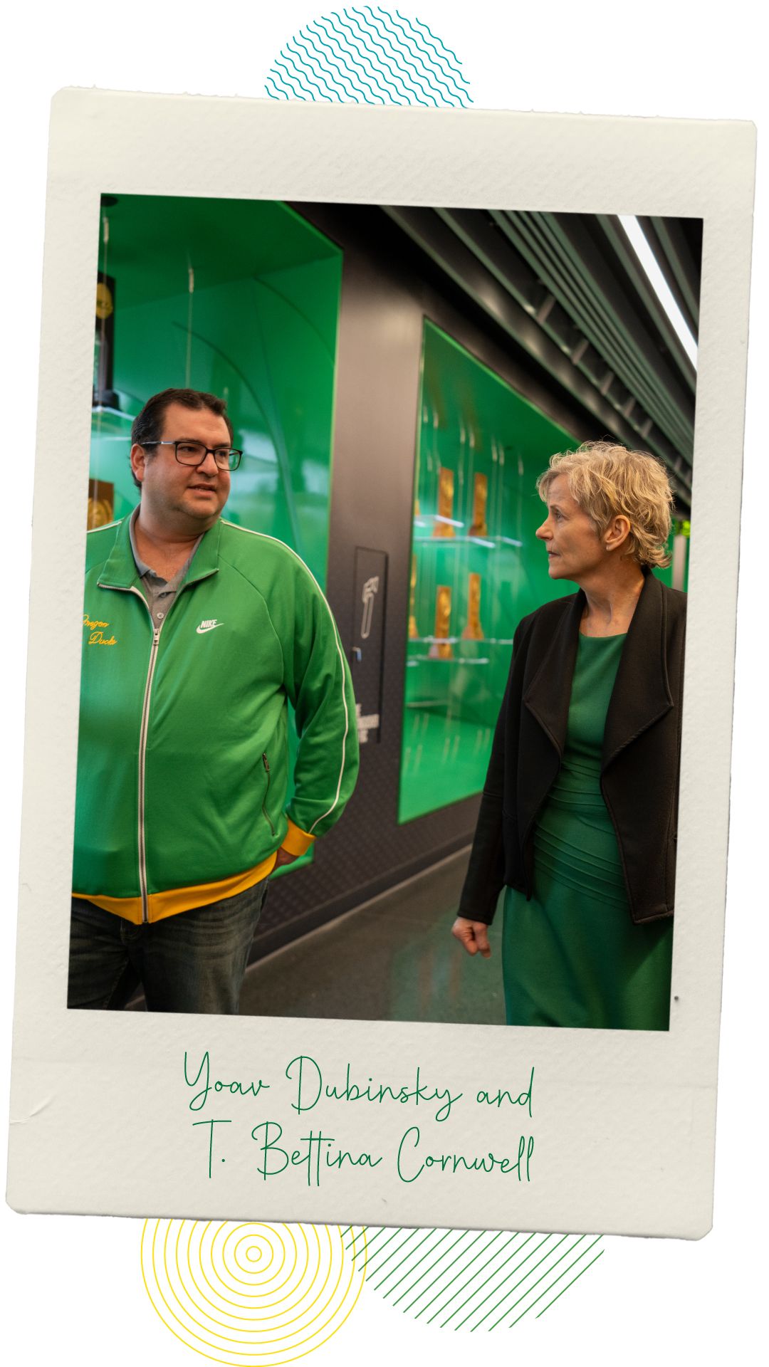Professors Yoav Dubinsky and T. Bettina Cornwell walking and chatting through the halls of the Hayward Field tower lobby.