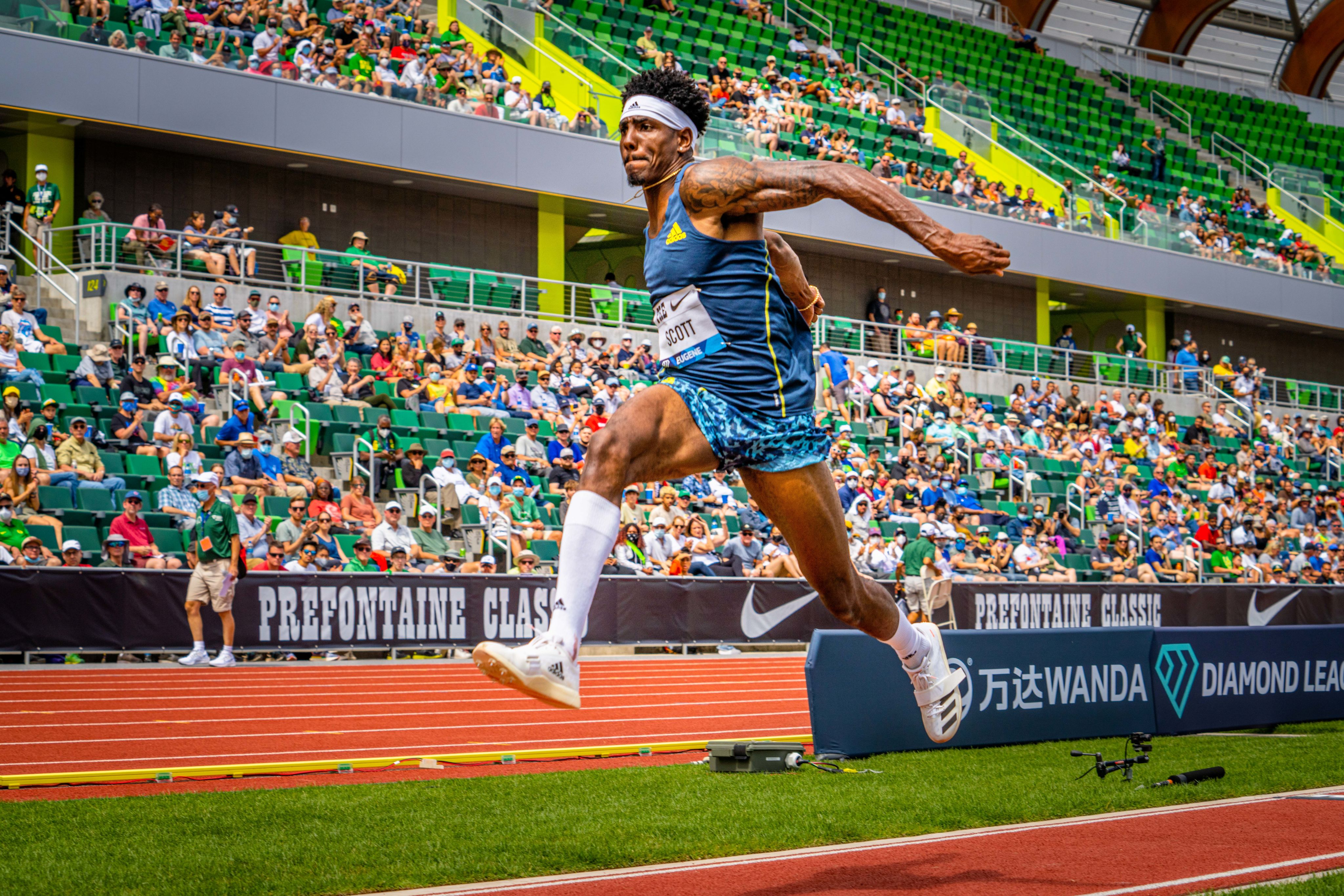 An athlete in the middle of competing in the long jump at Hayward Field.