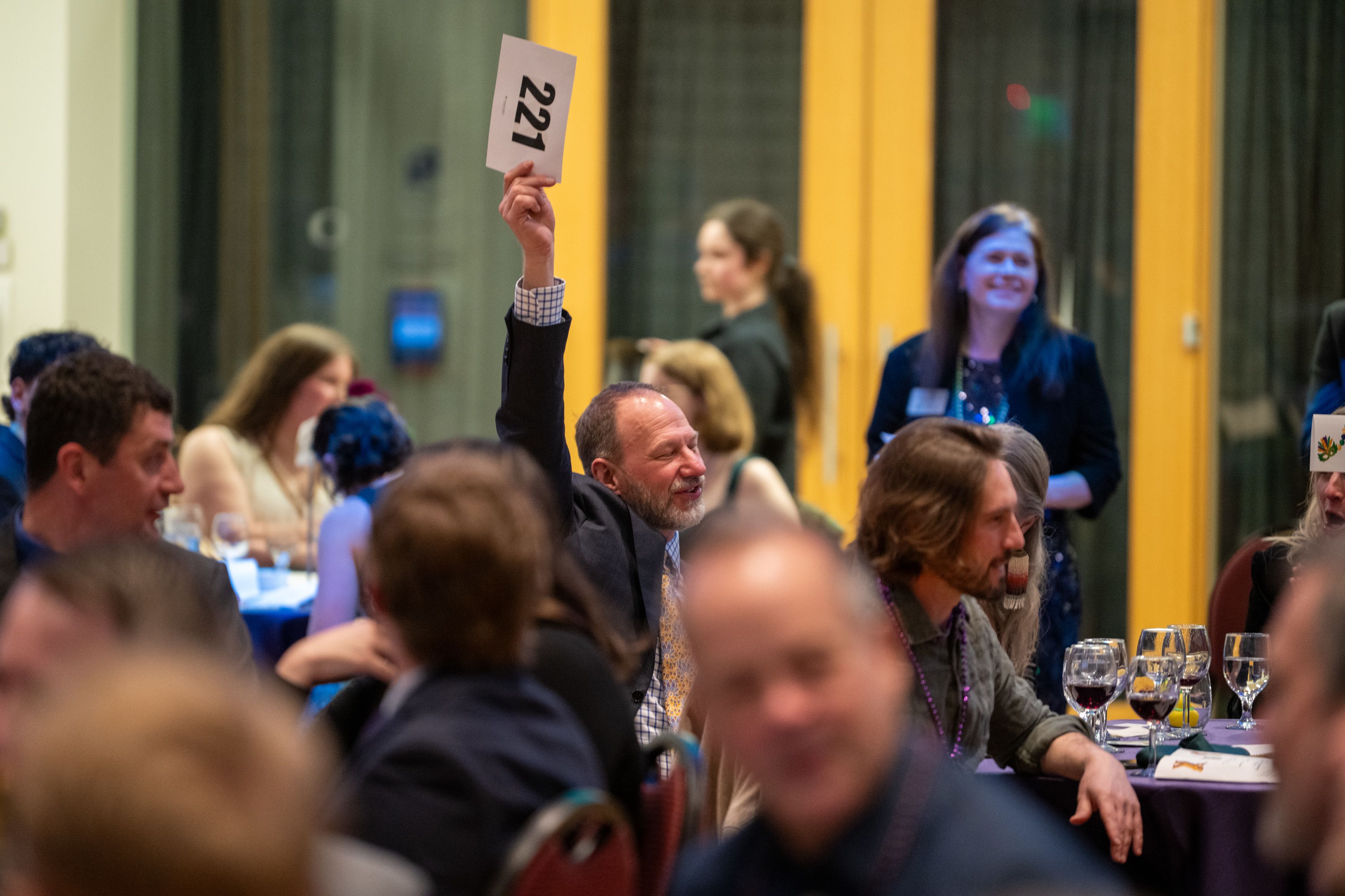 Guest raises paddle to signal their donation.