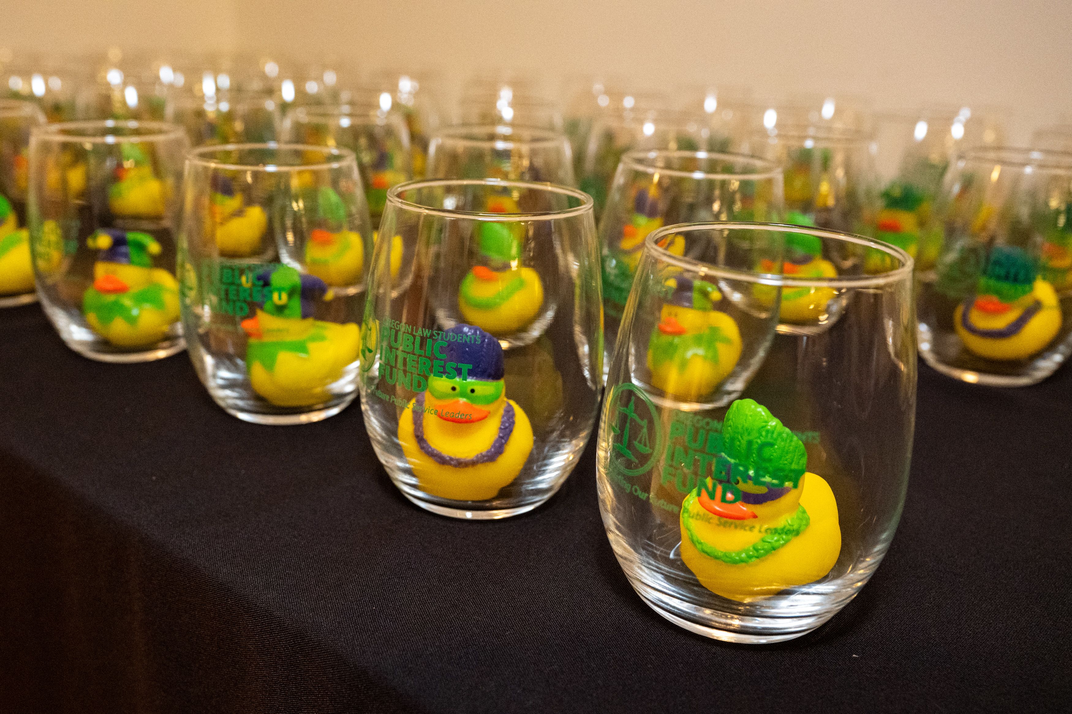 Close up of rows of OLSPIF wine glasses with mardi gras rubber duckies inside. 
