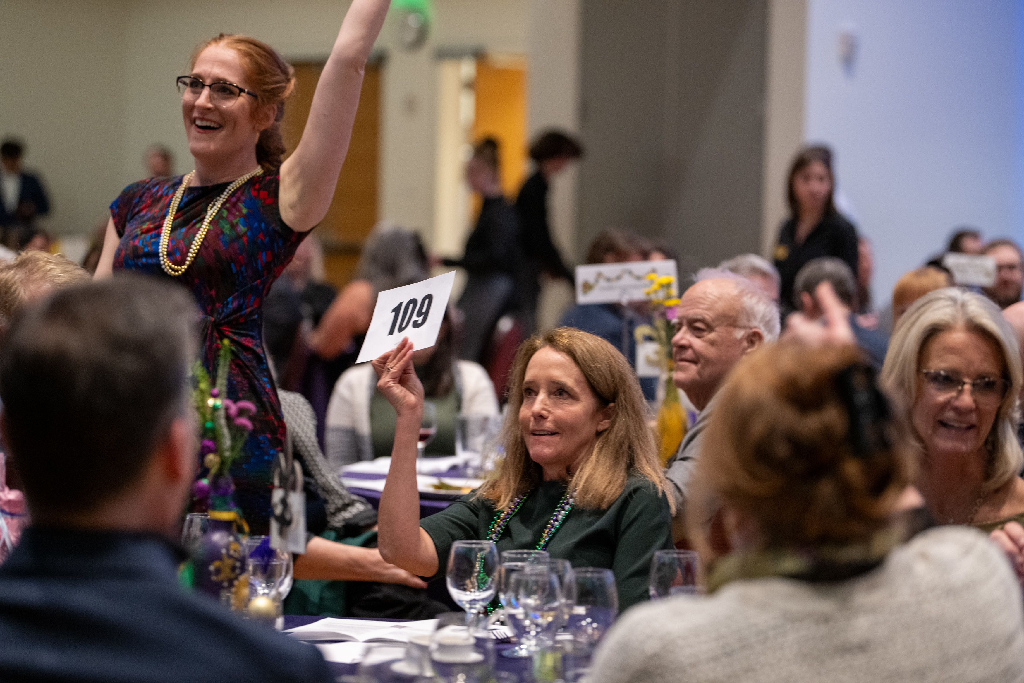 Lara Johnson rasises paddle for OLSPIF.