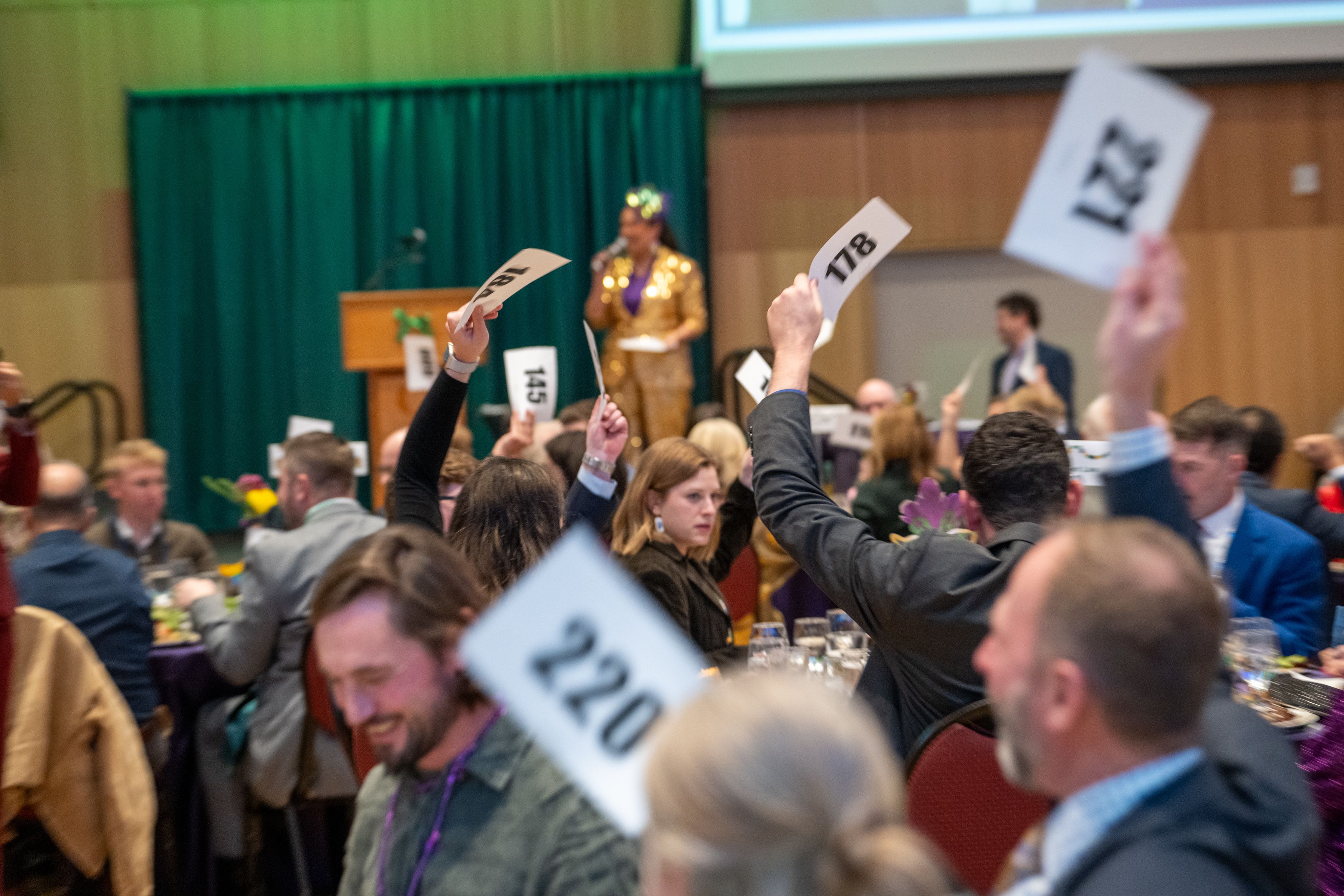 Guests raising their paddles to donate money for OLSPIF. 