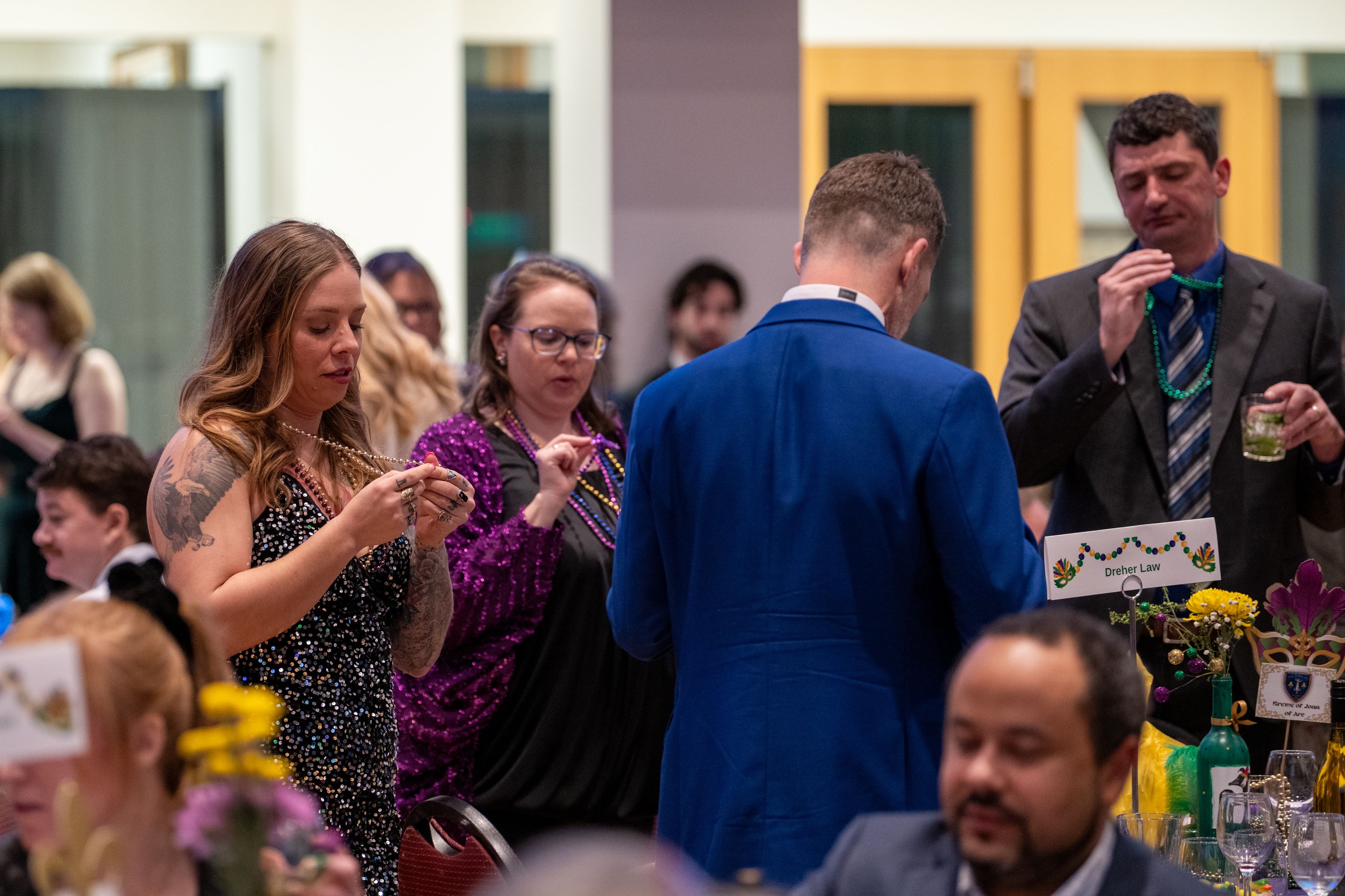 Guests look at their mardi gras beads to see if they have the winning necklace.