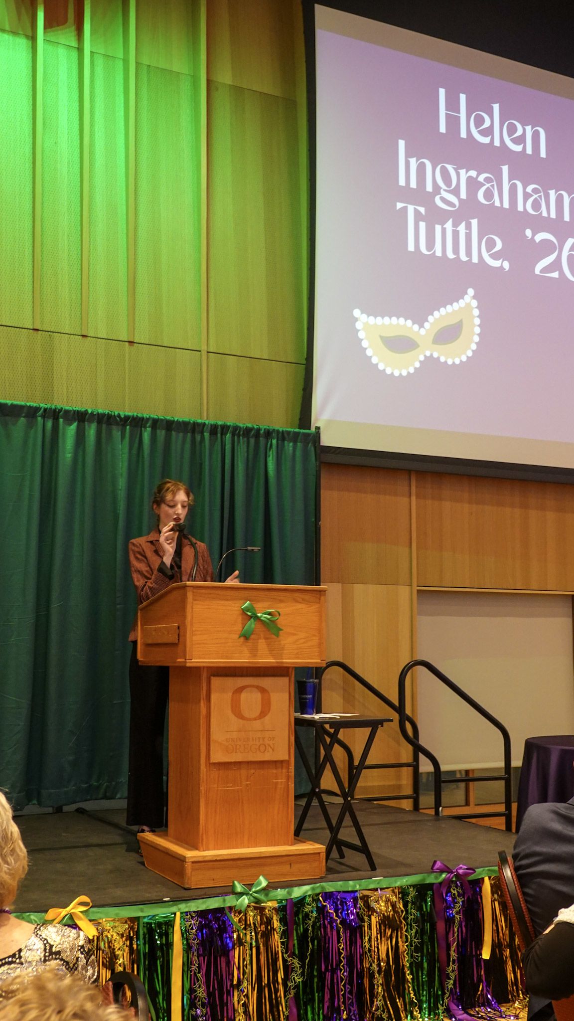 Helen Ingram Tuttle speaking at a microphone on the stage.