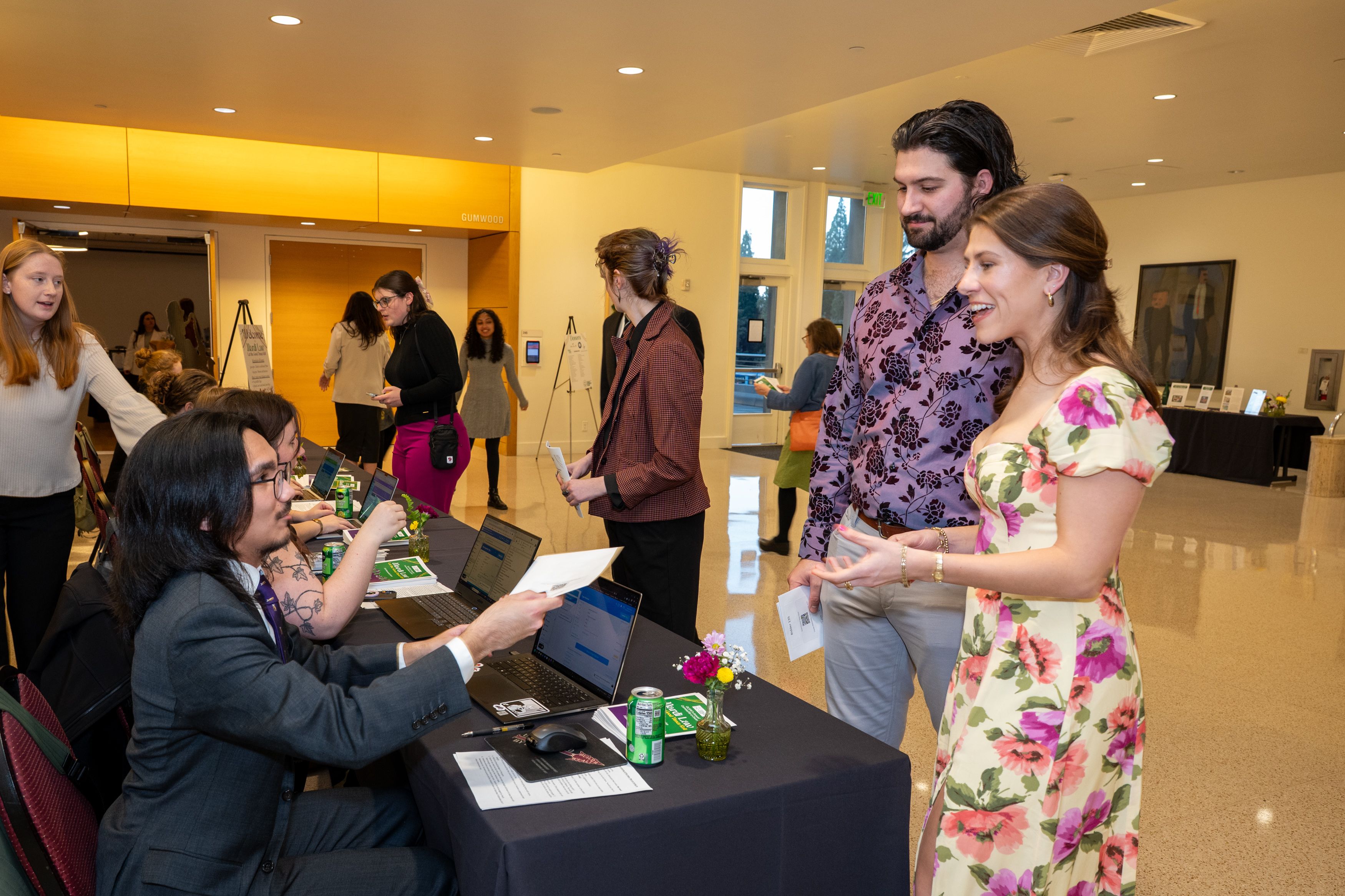 Man and woman checking in at the registration table. 