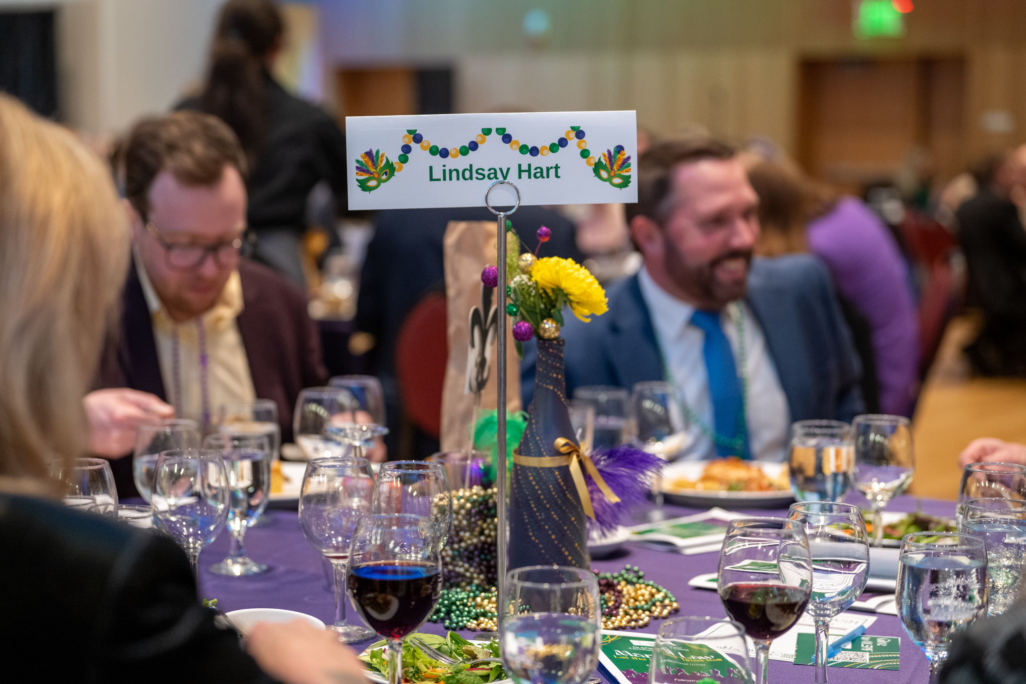 Lindsay Hart sponsored guest table with Mardi gras themed decorations.