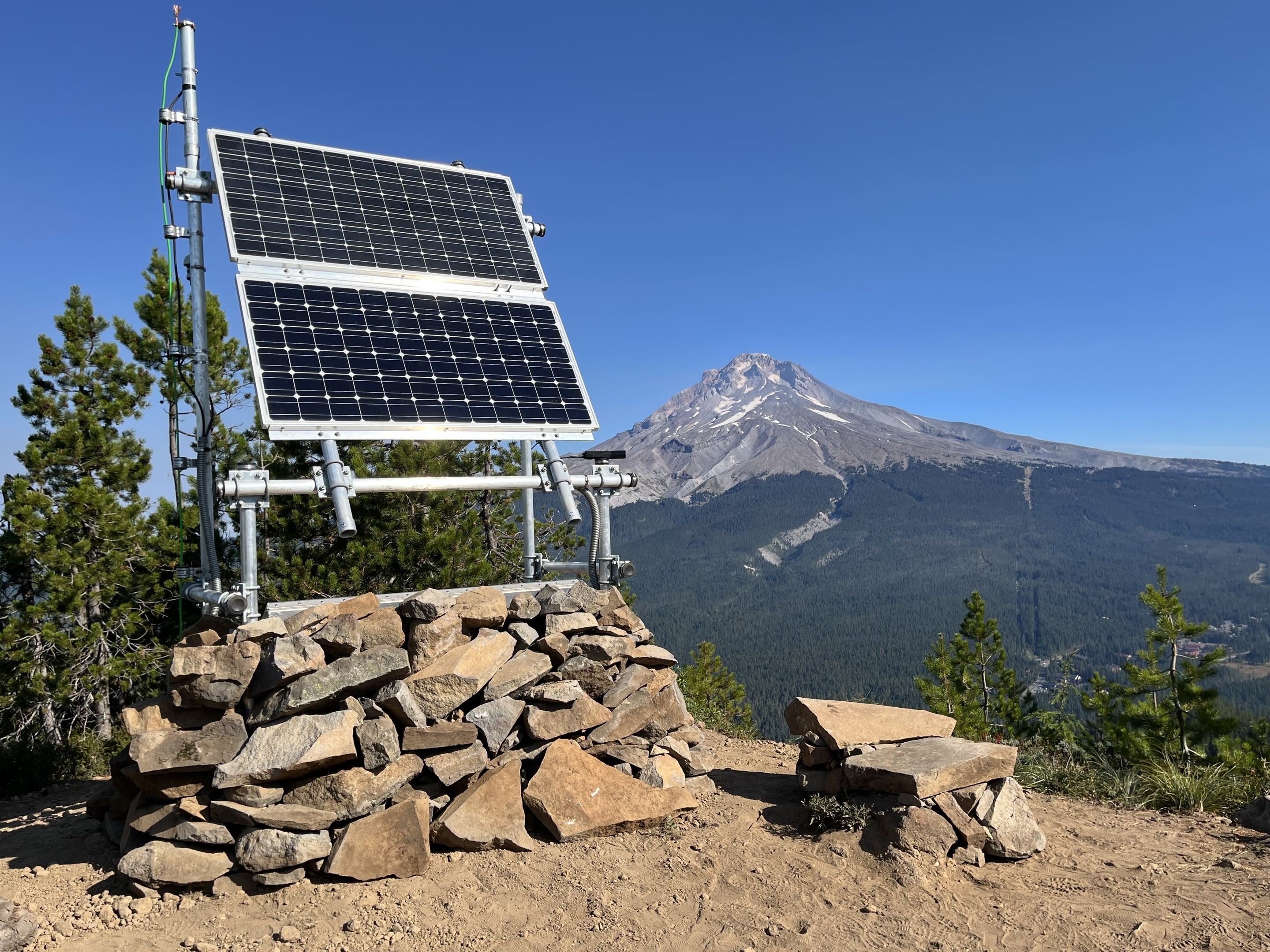 A seismic monitoring station with a mountain peak in the background.
